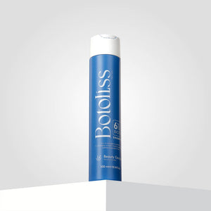 "Botoliss Biotin Shampoo" with a white cap is elegantly placed on a white surface, set against a light gray backdrop.